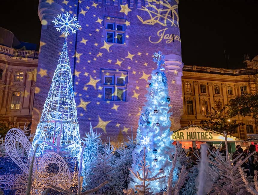 Illuminations de Noël au square Charles‑de‑Gaulle à Toulouse, avec décor féérique, sapins lumineux et projections sur les façades historiques.